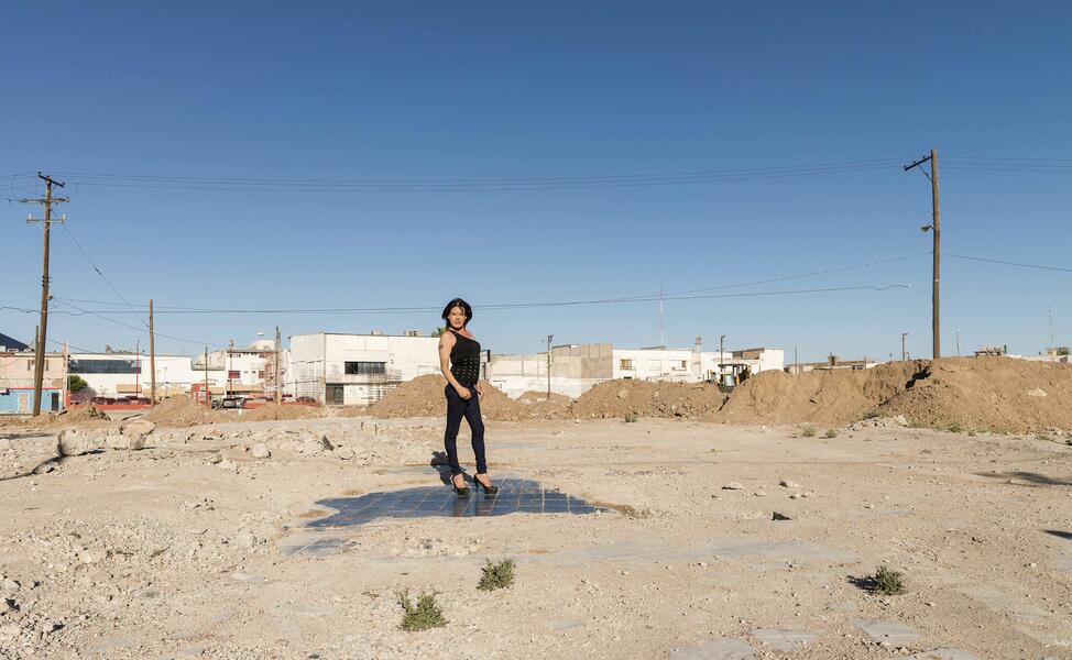 Trabajadora sexual transgénero de pie sobre la pista de baile de un club demolido en Ciudad Juárez, México C print en papel de algodón. Ph: Teresa Margolles.